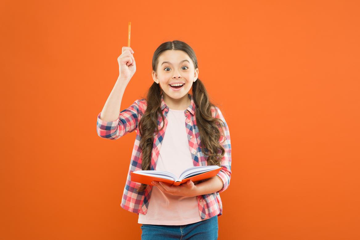 Little girl writing down her idea into a diary